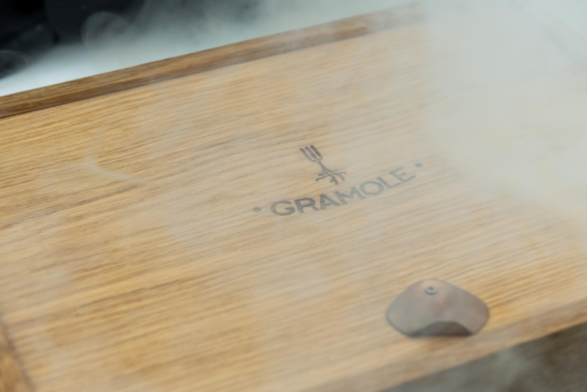 Tagliere in legno con il logo Gramole avvolto dal fumo